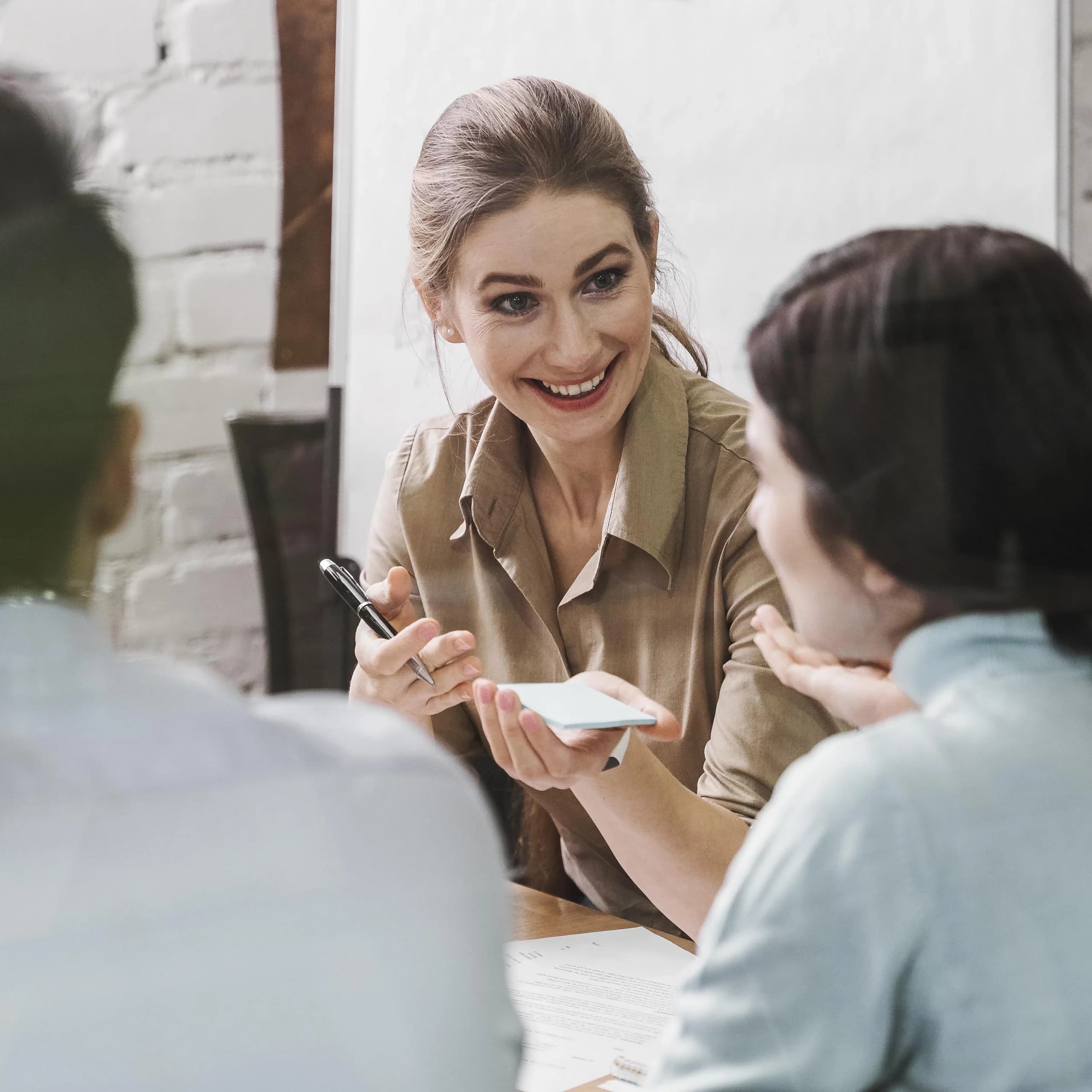 Une réunion productive entre une formatrice et deux clients pour un accompagnement Qualiopi à Lyon.