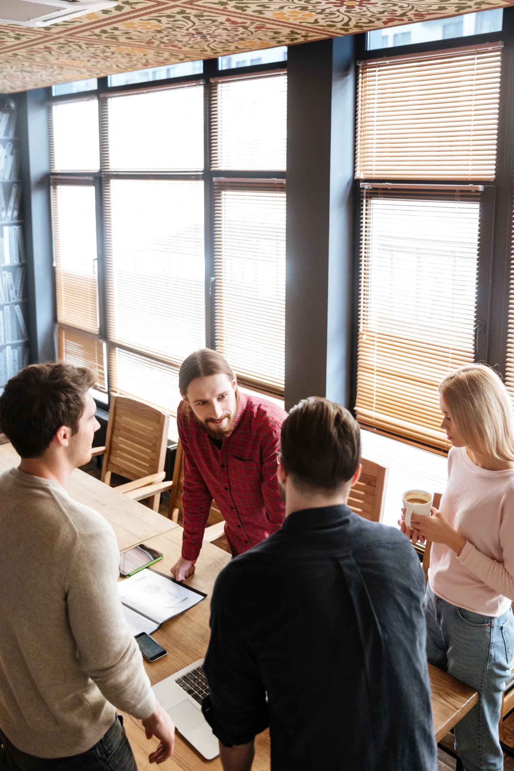 Une équipe en réunion autour d’une table dans un espace de coworking, illustrant un accompagnement Qualiopi à Paris.